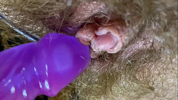 Баба с сильно волосатой пиздой ласкает клитор вибратором крупным планом.